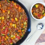 a large pot with a bowl of ground beef chili and a serving on the side
