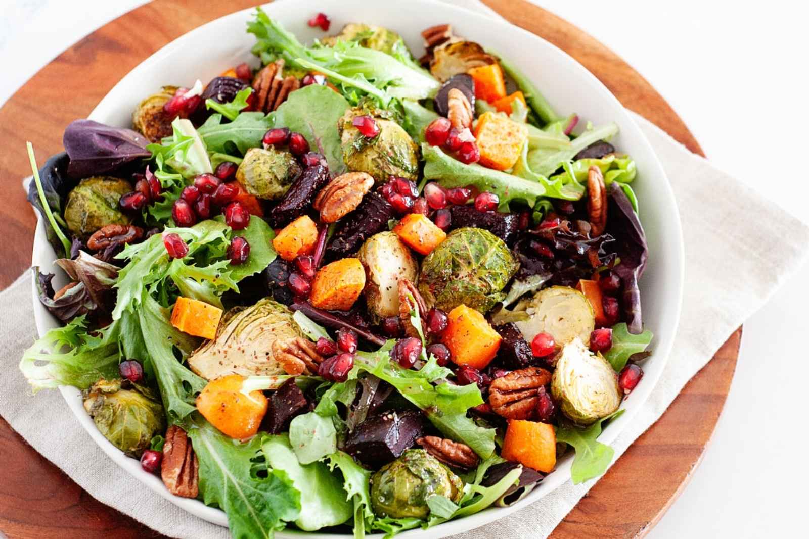 a large salad bowl with roasted winter veggies and greens