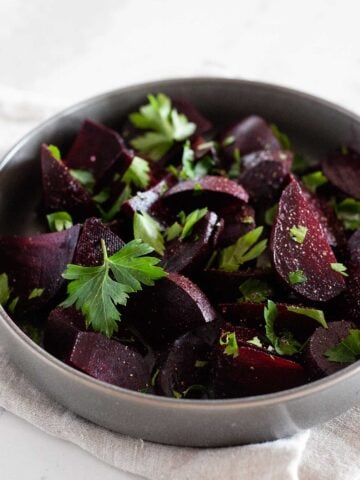 large dish of balsamic beets topped with greens