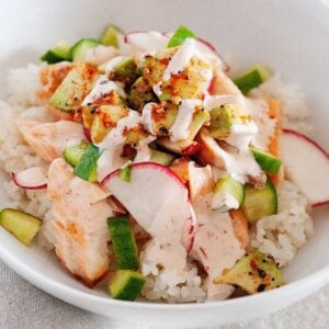 a salmon and rice bowl with spicy dressing