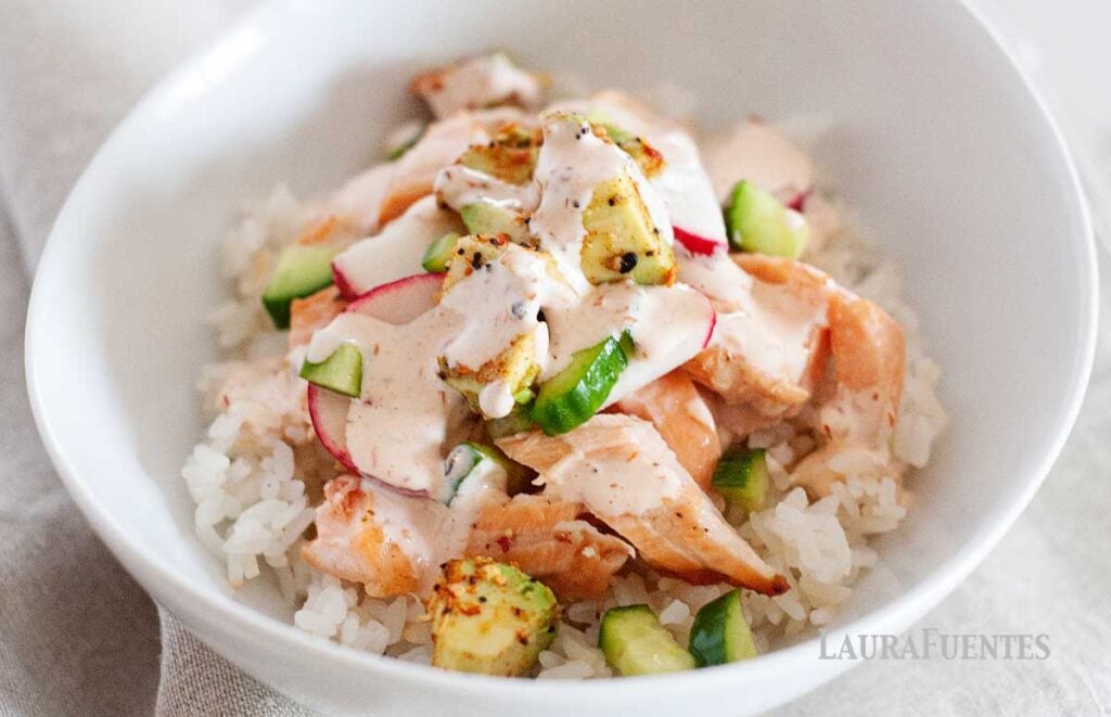 a salmon and rice bowl with spicy dressing