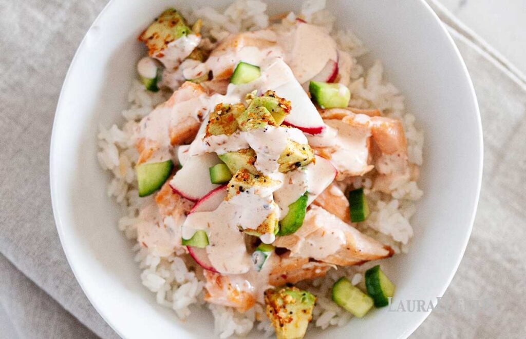 a salmon and rice bowl with spicy dressing