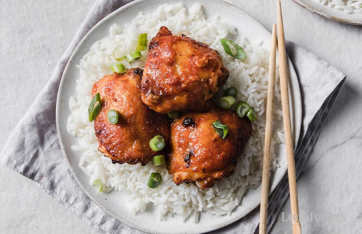 plage of rice, chicken thighs and chopsticks
