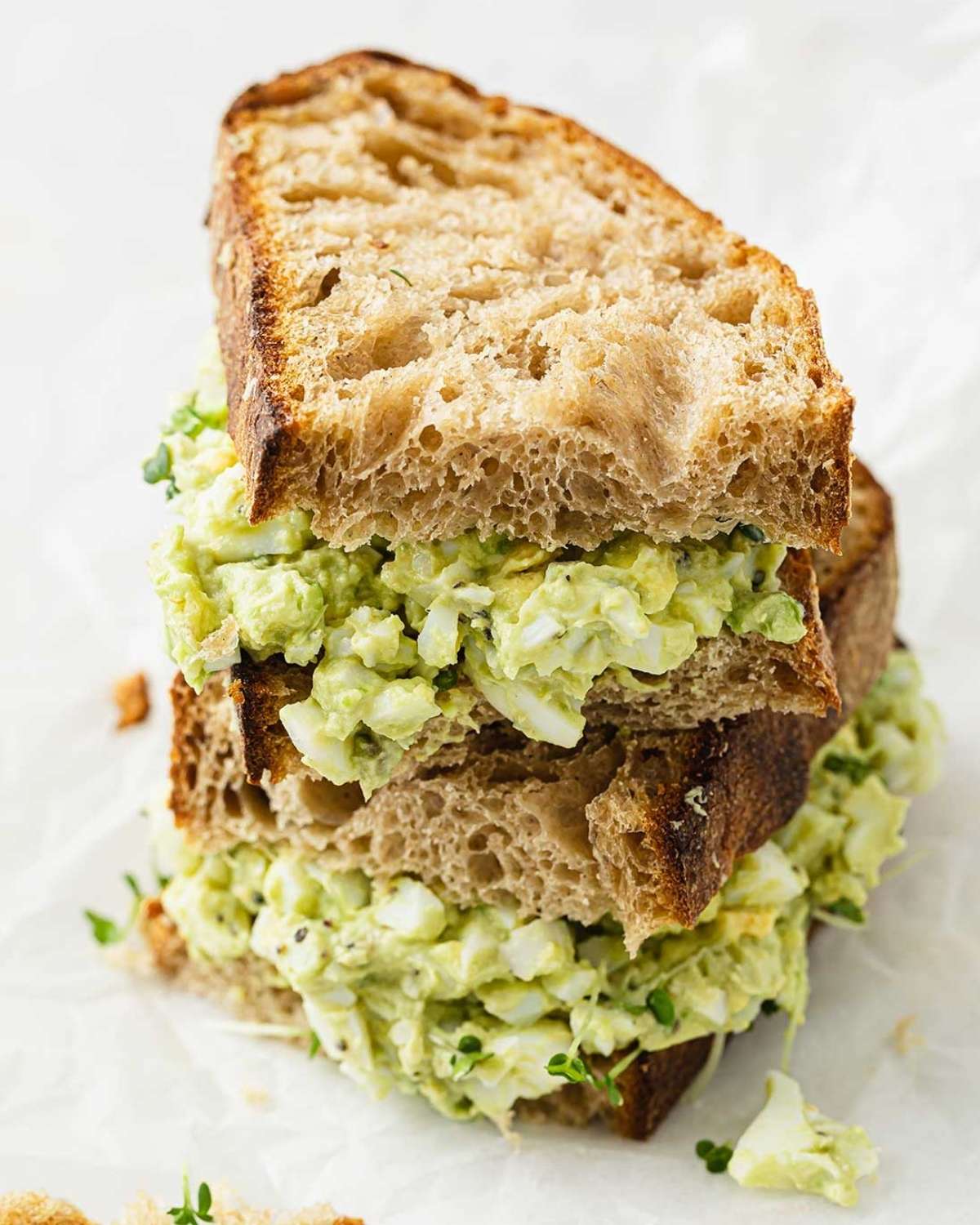 a triple decker filled with avocado egg salad