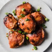 top view of sriracha chicken thighs on a serving plate
