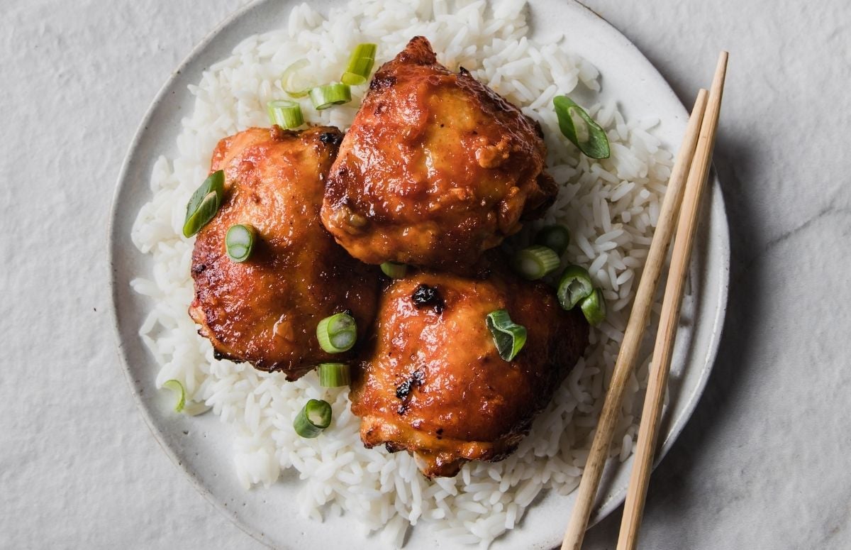 plage of rice, chicken thighs and chopsticks