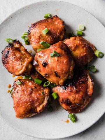 top view of sriracha chicken thighs on a serving plate
