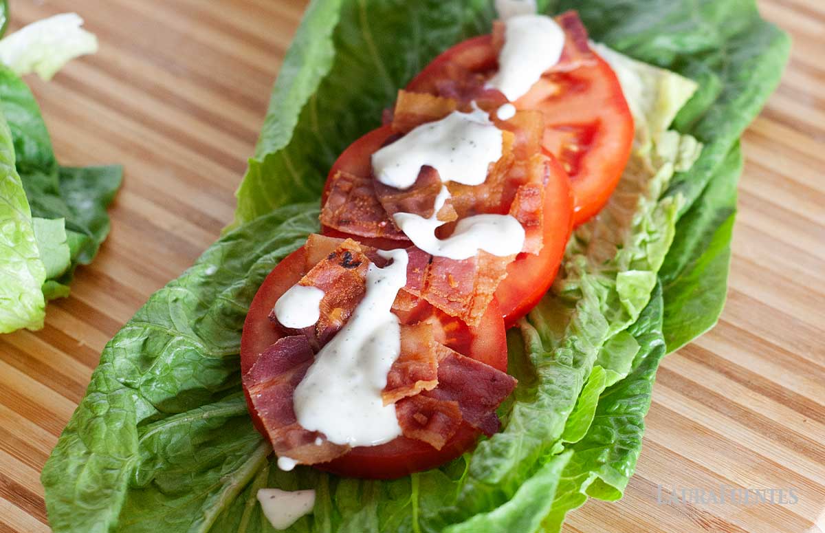 large BLT lettuce wrap on a cutting board