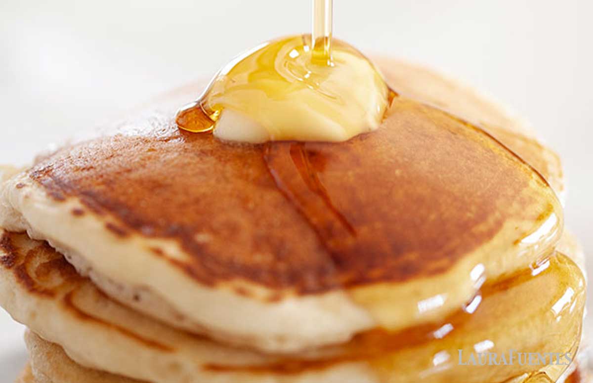 Stack of pancakes topped with butter and syrup.