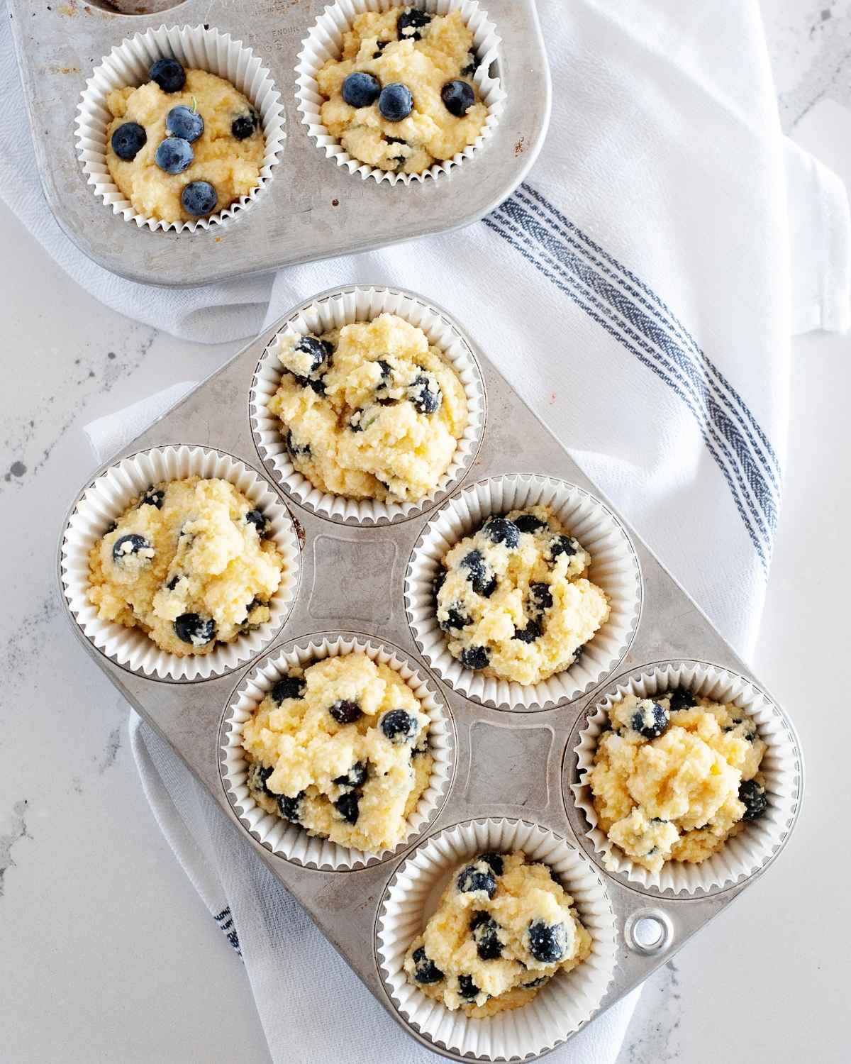 muffin tin with blueberry coconut flour muffin batter