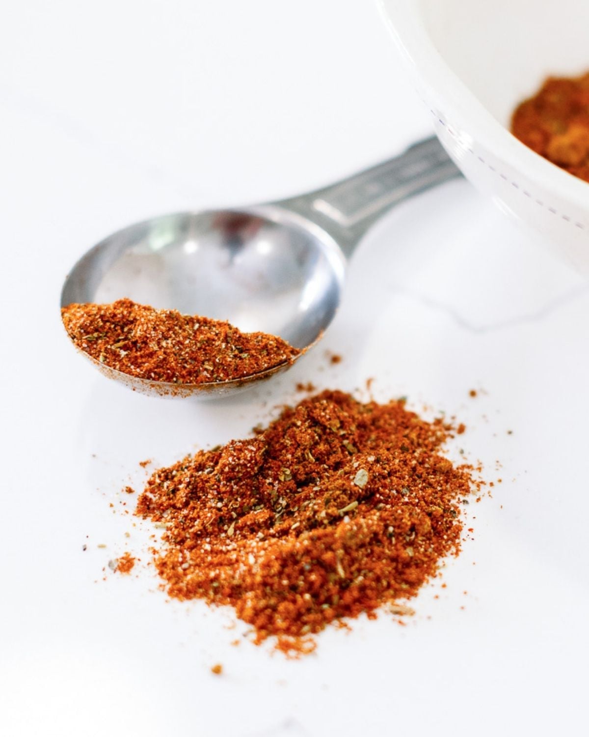 seasoning spilled on a countertop with a large tablespoon