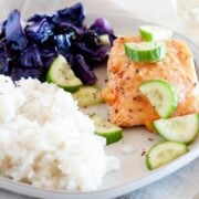 salmon, cabbage, rice and cucumber slices on a plate