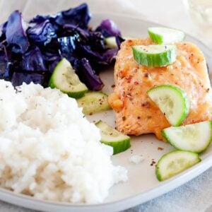 salmon, cabbage, rice and cucumber slices on a plate