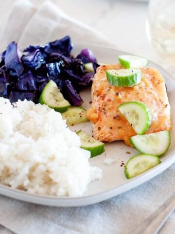 salmon, cabbage, rice and cucumber slices on a plate