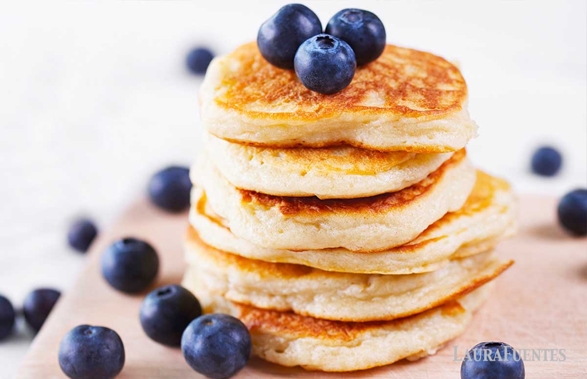 large stack of coconut flour pancakes topped with blueberries