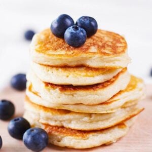 stack of low carb coconut flour pancakes stacked to how size topped with blueberries