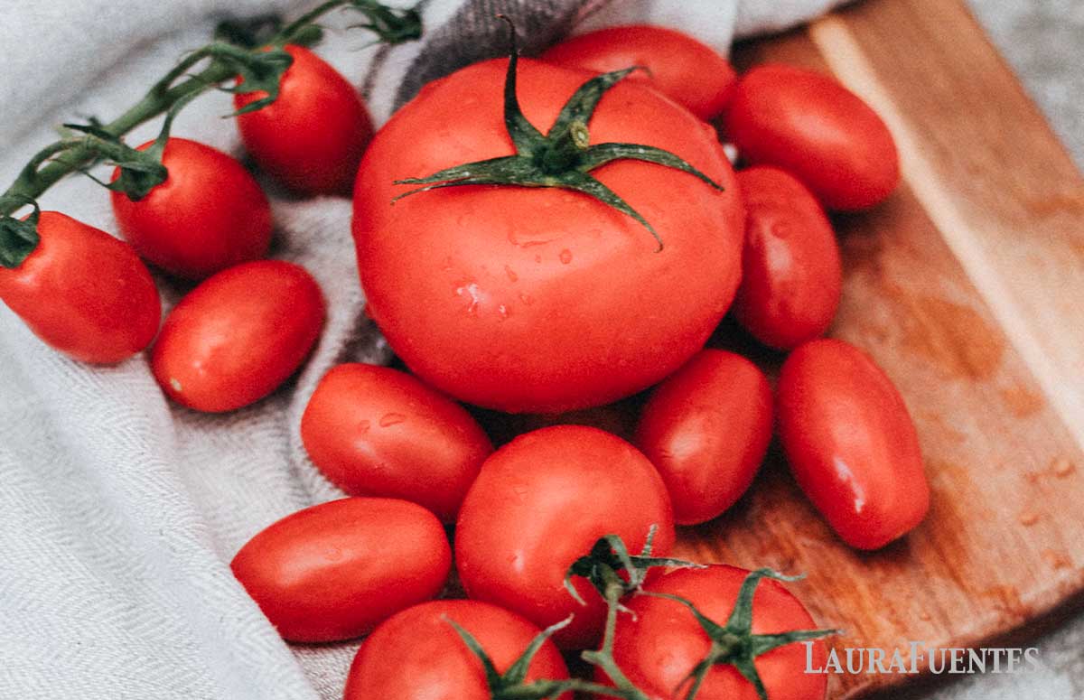 freshly washed tomatoes on a cutting board