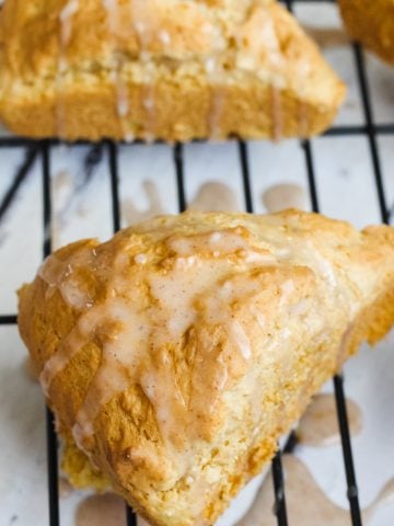 two paleo pumpkin scones on a cooling rack