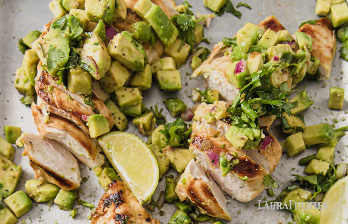 two cilantro lime chicken breasts topped with chunky avocado salsa