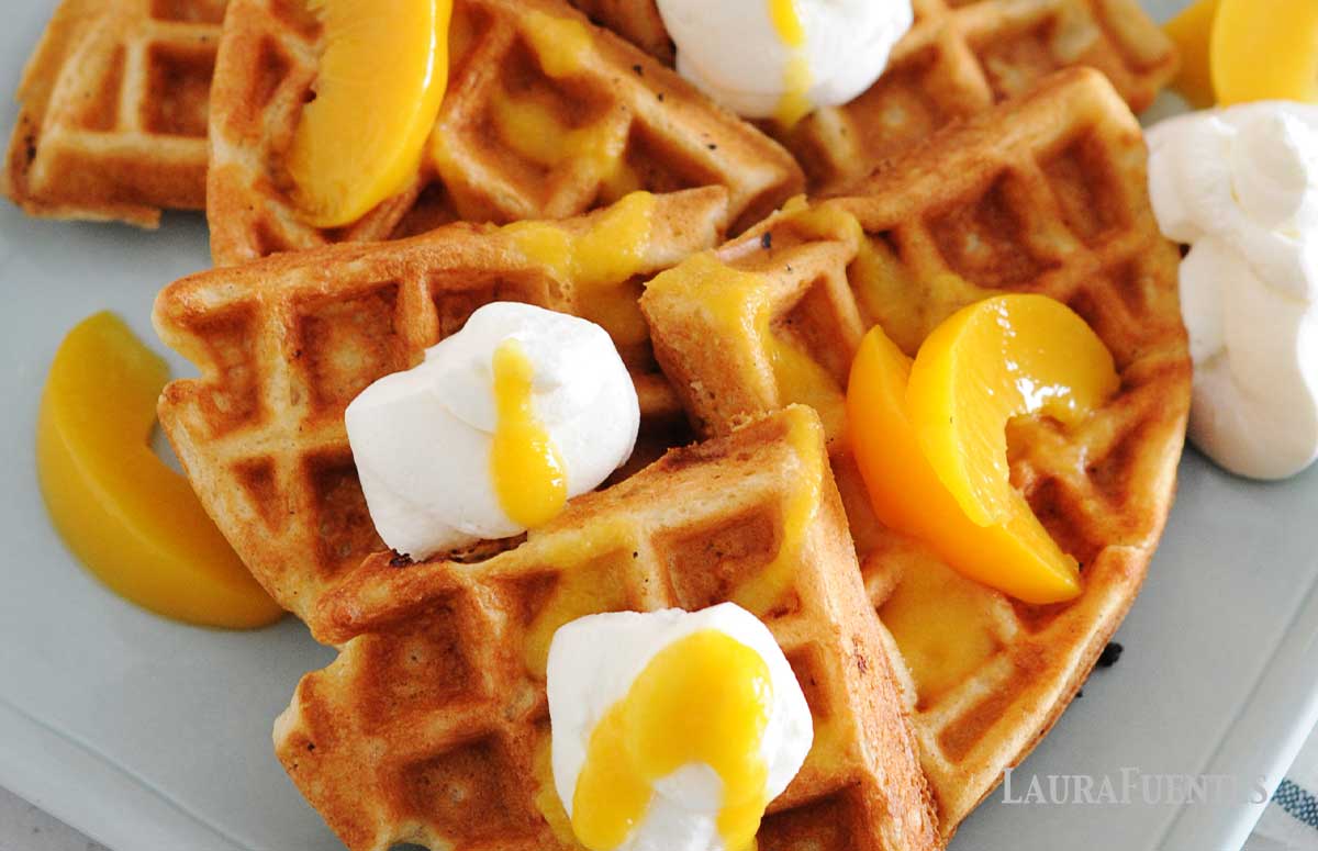 peach waffles with small bottle of peach syrup to one side