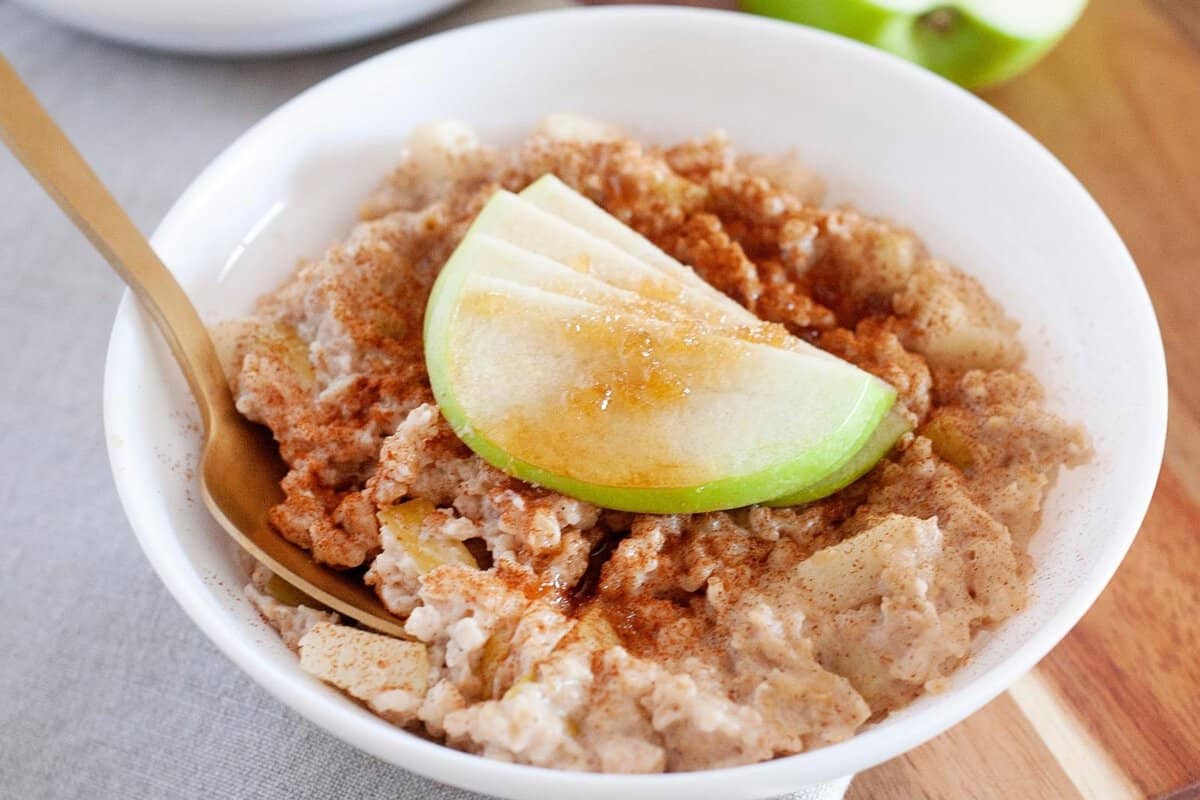 a bowl of overnight oatmeal topped with cinnamon and apple slices