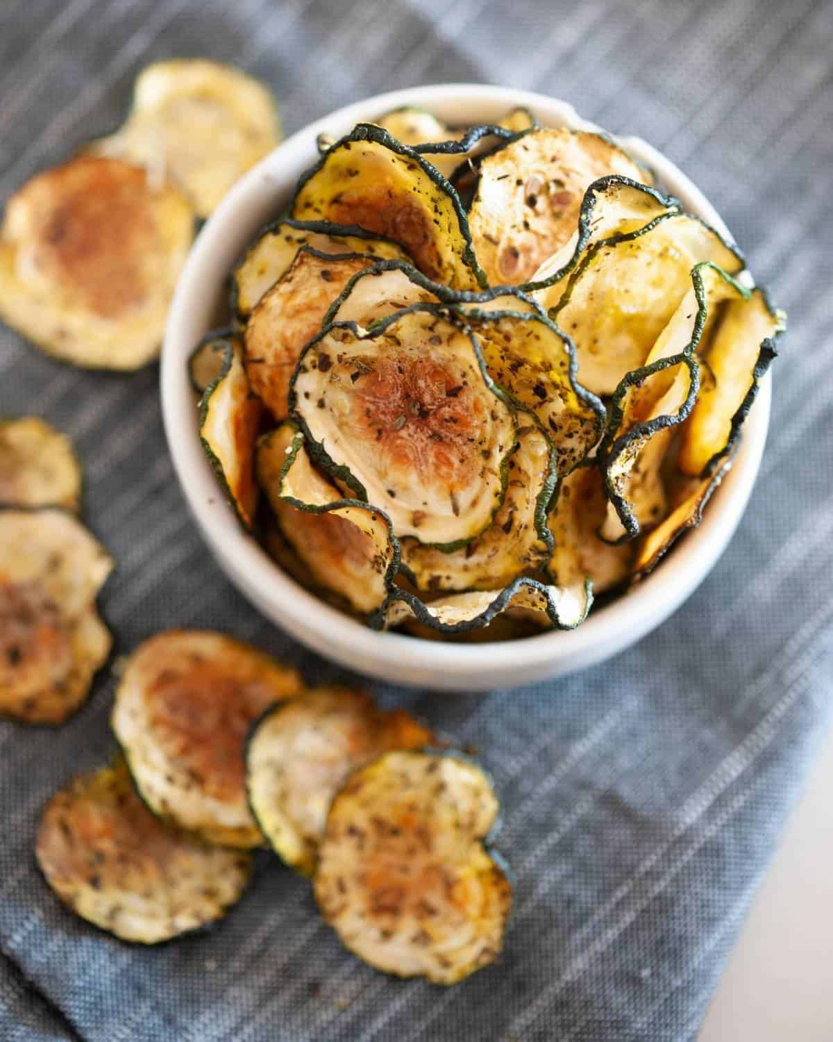 overhead view of a small white bowl of zucchini chips with no breading