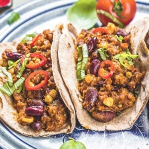 two chili tacos on a blue plate