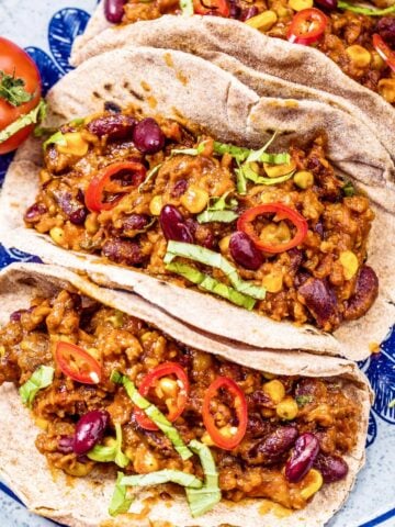 three chili tacos on a blue plate