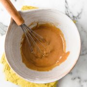 large bowl of thai peanut dressing with a whisk