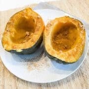 two cooked acorn squash halves on a plate