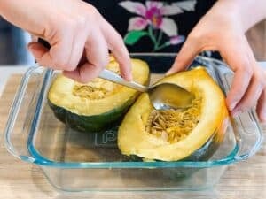removing the seeds from two acorn squash halves