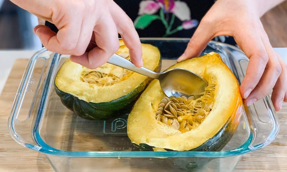 removing the seeds from two acorn squash halves