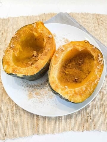 two cooked acorn squash halves on a plate