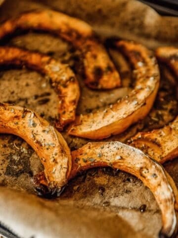 roasted acorn squash slices on a baking sheet