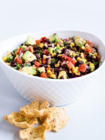 a bowl of southwest quinoa salad with avocado, corn and beans
