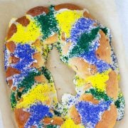 overhead of king cake with green, yellow, and purple sprinkles