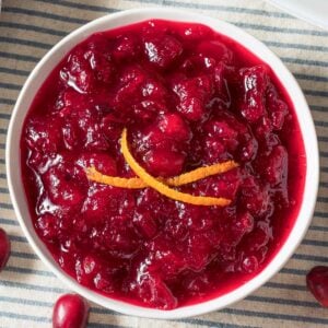 overhead view of a bowl of orange cranberry sauce at a table