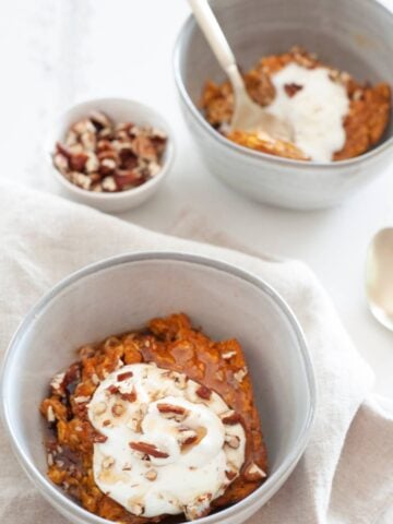 two bowls of pumpkin baked oatmeal topped with nuts