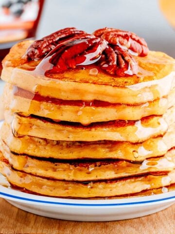 large stack of pecan pancakes topped with sliced pecans