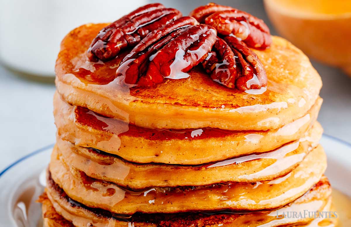 large stack of pecan pancakes topped with sliced pecans