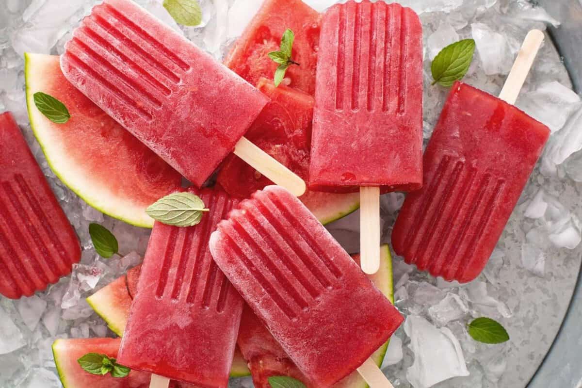 Watermelon Pops MOMables.com watermelon popsicles over ice and watermelon pieces