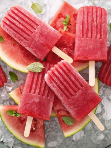 watermelon popsicles over ice and watermelon pieces