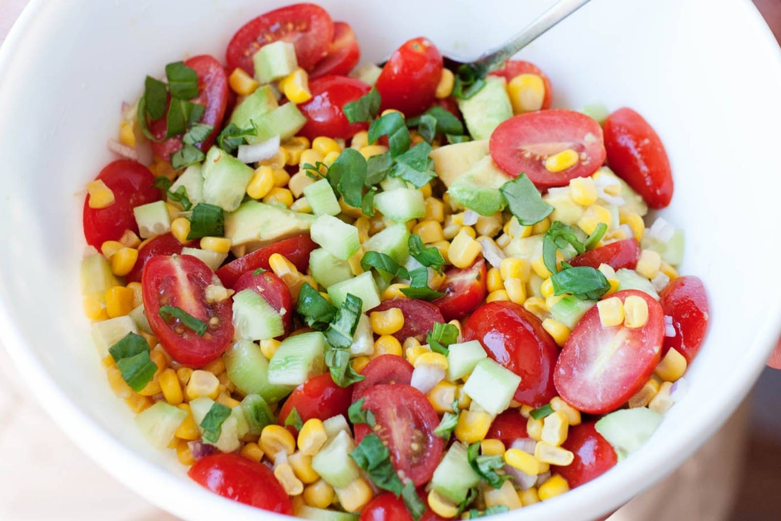 a bowl of corn tomato salad