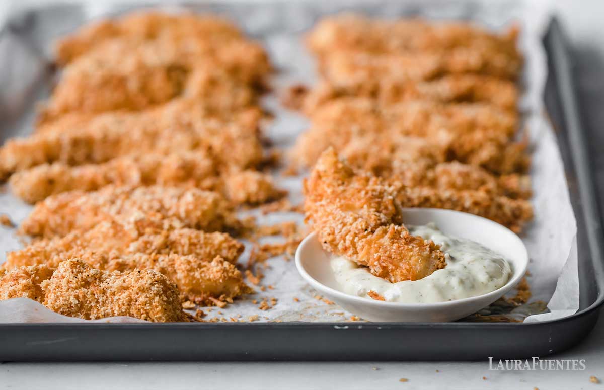 homemade fish stick dipping in sauce
