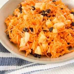 a bowl of carrot raisin salad with pineapple