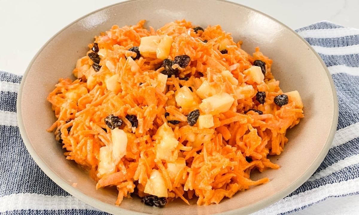 a bowl of carrot raisin salad with pineapple