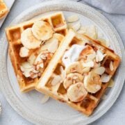 two banana waffles overhead view with sliced bananas on a plate