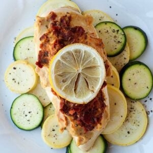 hummus chicken over a bed of squash topped with a lemon slice
