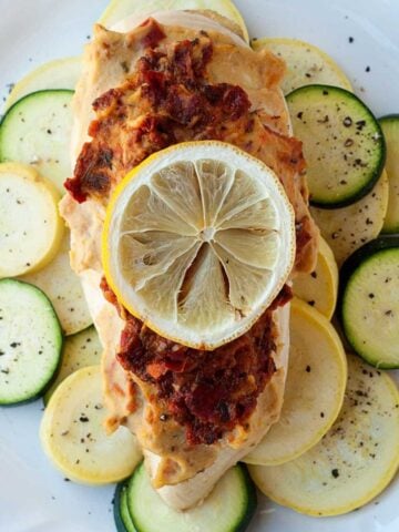 hummus chicken over a bed of squash topped with a lemon slice