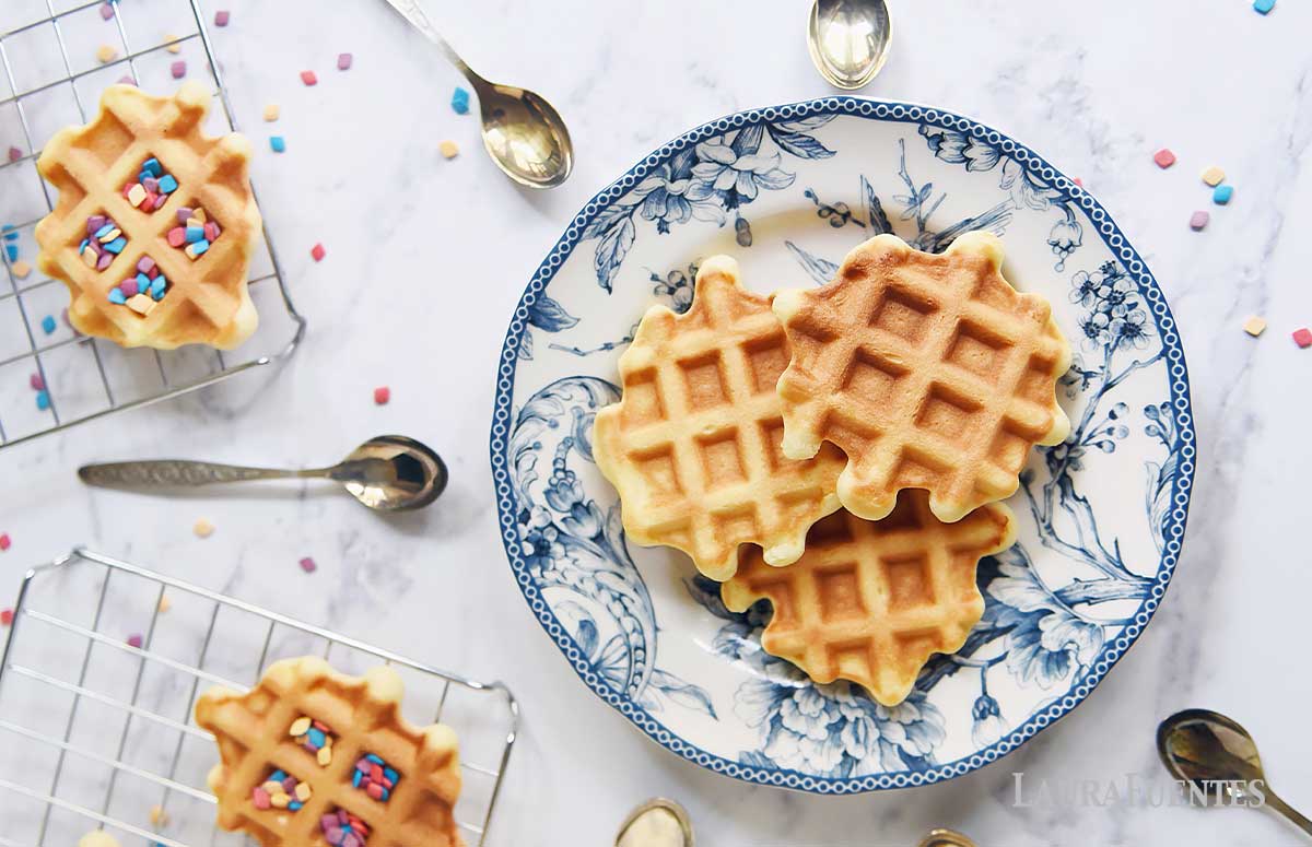 plate of 3 birthday cake waffles with lots of spoons around it